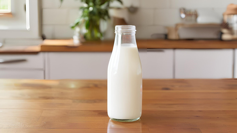 A bottle of milk on a wooden counter.