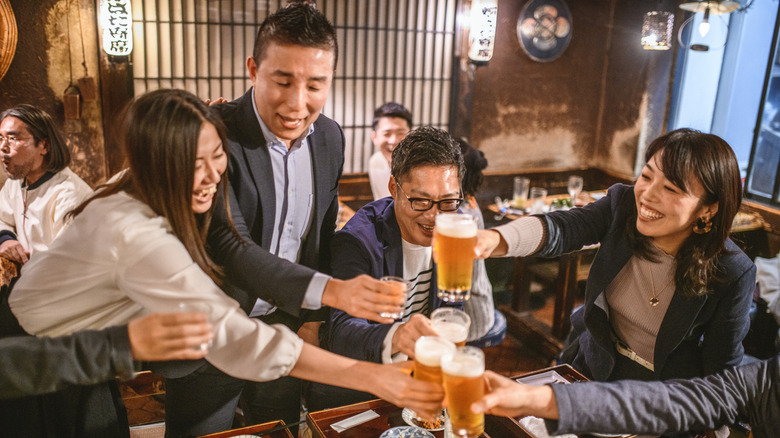 Young people toasting with beer at a Japanese restaurant.