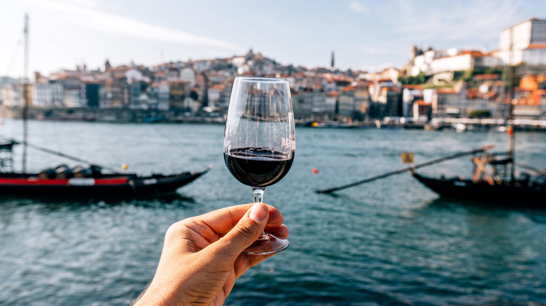 An individual holding a glass of fortified wine.