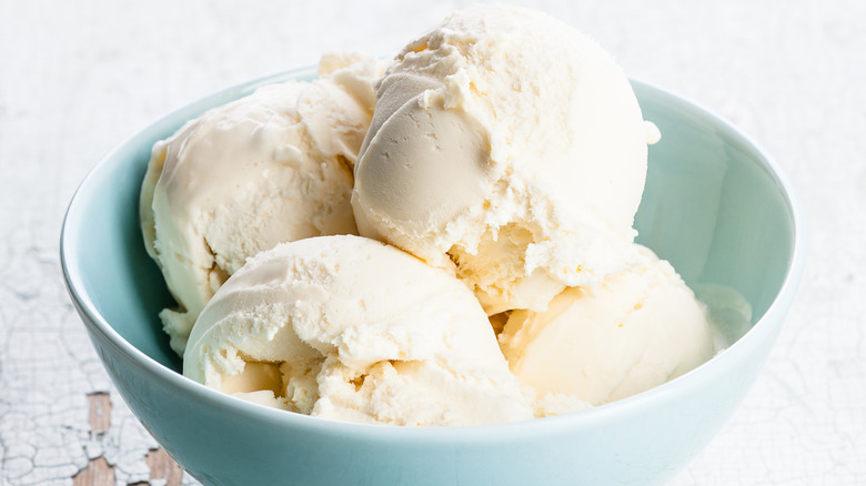 A light blue bowl of vanilla cottage cheese ice cream on a white background