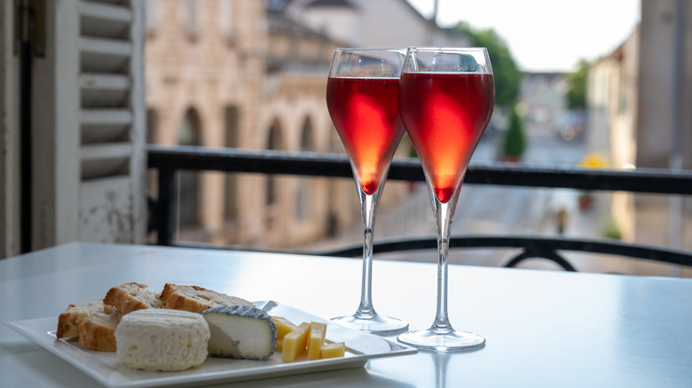 Kir royales for two are served on a balcony alongside a cheese plate.