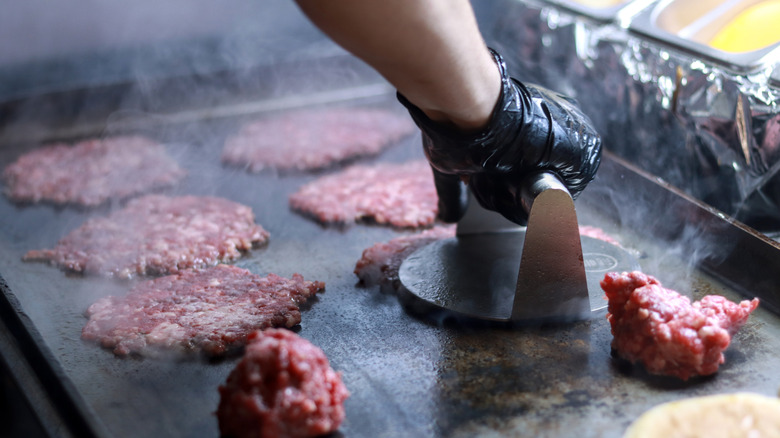 Person smashing burgers