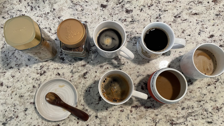 Assorted coffee cups and coffee mixes are displayed.