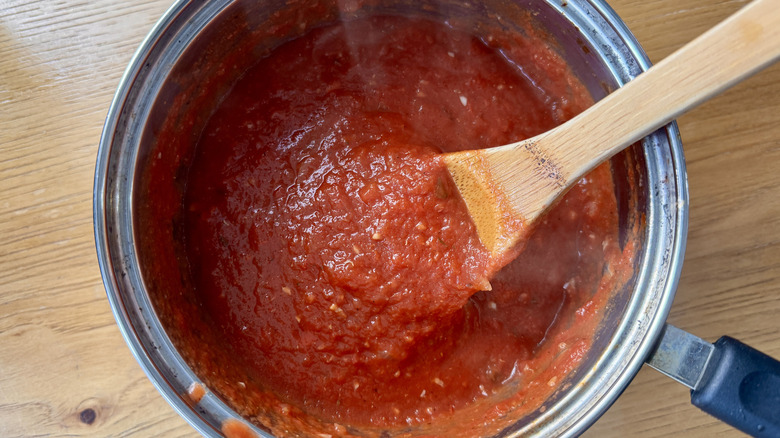 tomato sauce and a wooden spoon in a metal pot