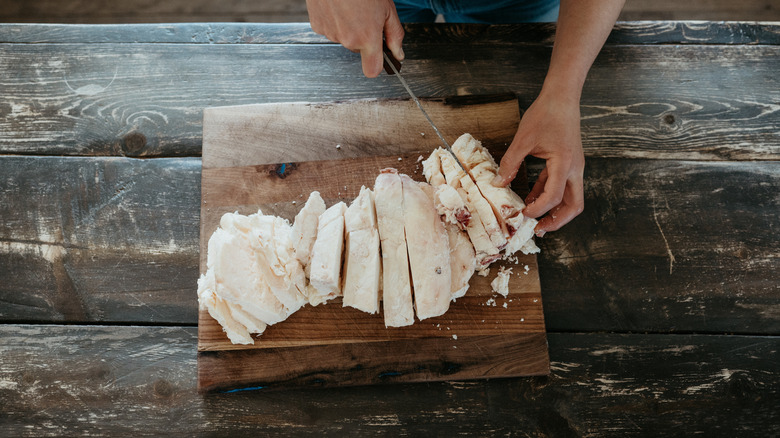 A chef chopping chunks of beef tallow.