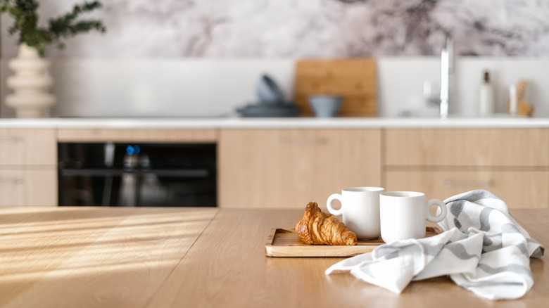 tray with cups and pastry on kitchen island
